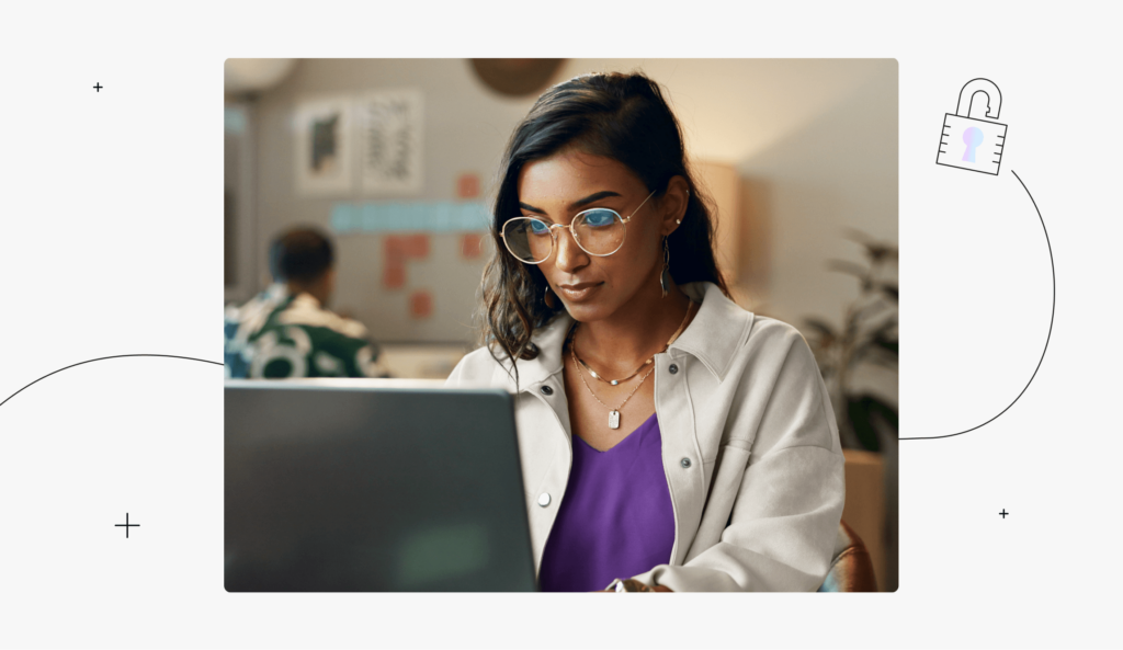 A person is looking intently at a laptop screen in a workplace setting.